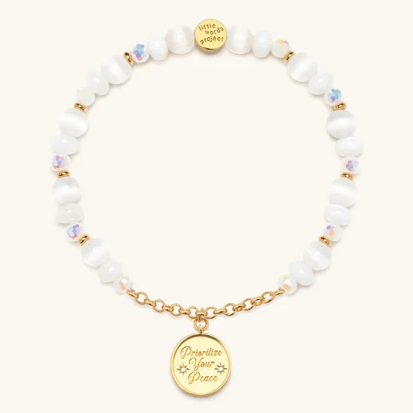 Prioritize Your Peace charm bracelet with white beads and a gold medallion