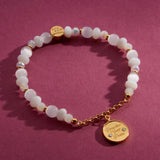 Prioritize Your Peace charm bracelet on a burgundy backdrop