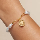 Prioritize Your Peace charm bracelet worn on a wrist, charm turned to the back