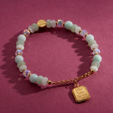 Trust Your Journey charm bracelet on a burgundy backdrop