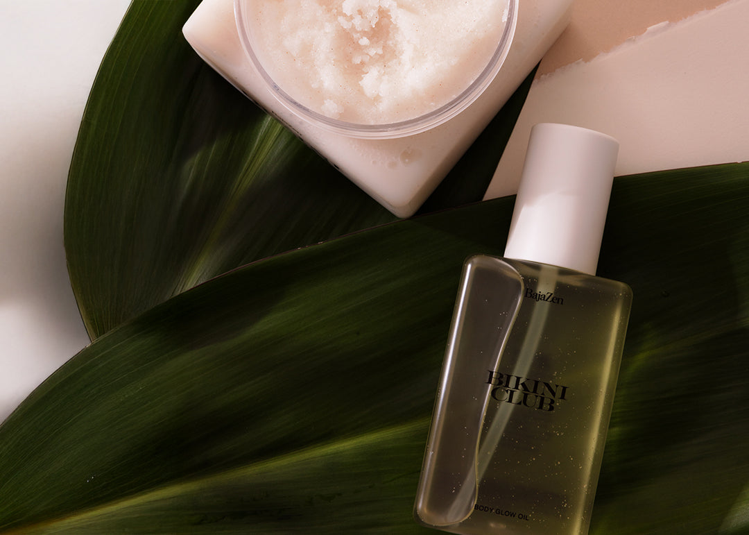 Skincare products including a bottle and jar on a leaf with a neutral background