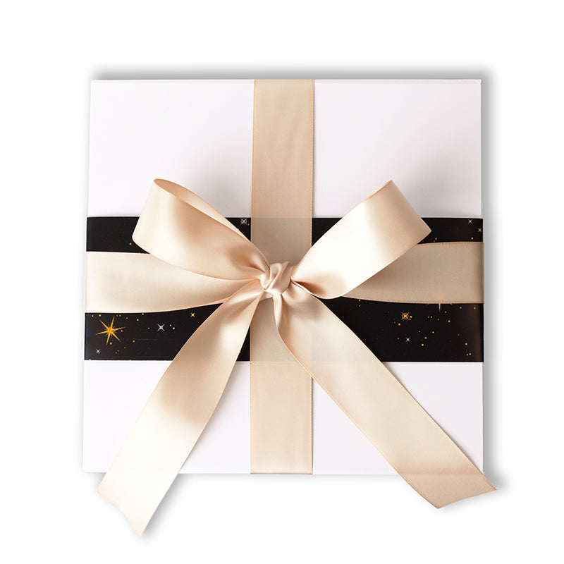 A white gift box with a gold ribbon bow and a black and gold star pattern on the wrapping paper.