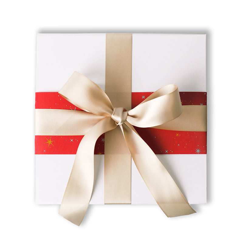 A gift box with a scarlet stardust pattern, featuring a large gold bow on the front.