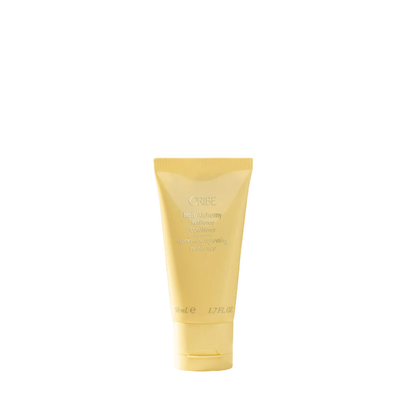 Yellow tube of Creme of Nature hair product on a white background