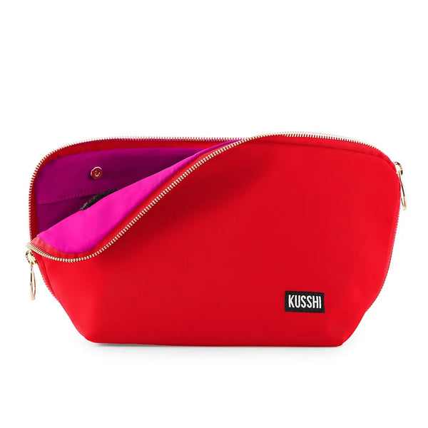 Candy Apple Red/Pink, A red zippered pouch with a gold zipper and a small black KUSSHI label on the front, shown open to reveal a bright pink interior.