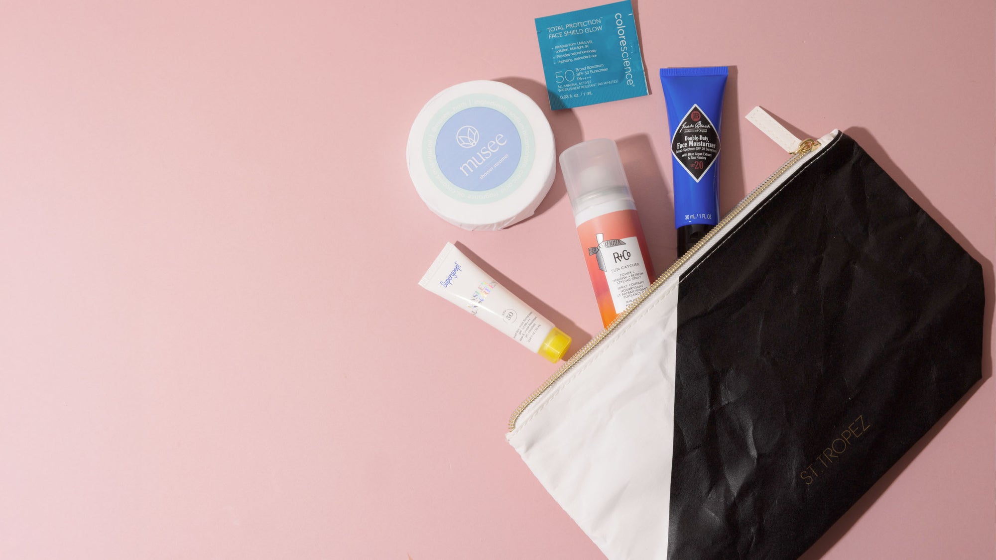 Collection of skincare products on a pink background