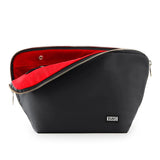 KUSSHI | Vacationer Makeup Bag — Black/Red, A black zippered cosmetic pouch with a bright red interior lining and gold-tone zipper, shown open on a white background. The brand name 'KUSSHI' is printed in white on the lower right front.