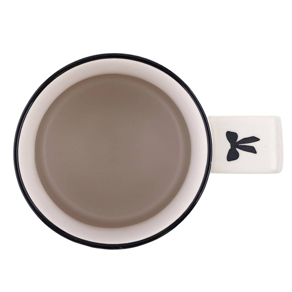 White ceramic mug with black rim and tree design, top view on neutral background