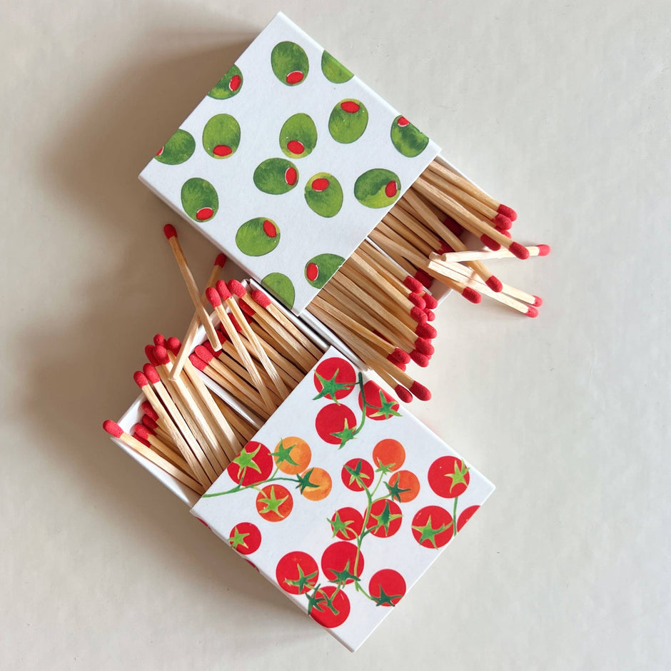 Tomato and cactus design matchboxes with red-tipped wooden matches on white background