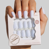 White almond-shaped press-on nails displayed on model's hand with packaging box