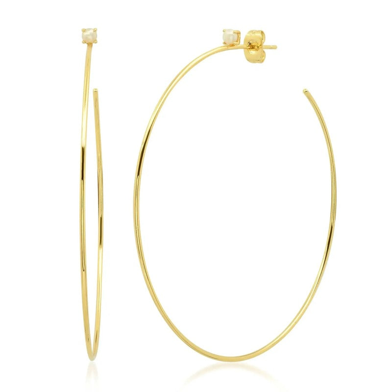 Large gold hoop earrings with pearl stud accents on white background