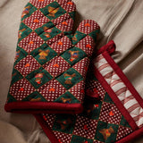 Beary Christmas oven mitts with red and green plaid pattern displayed on cream fabric