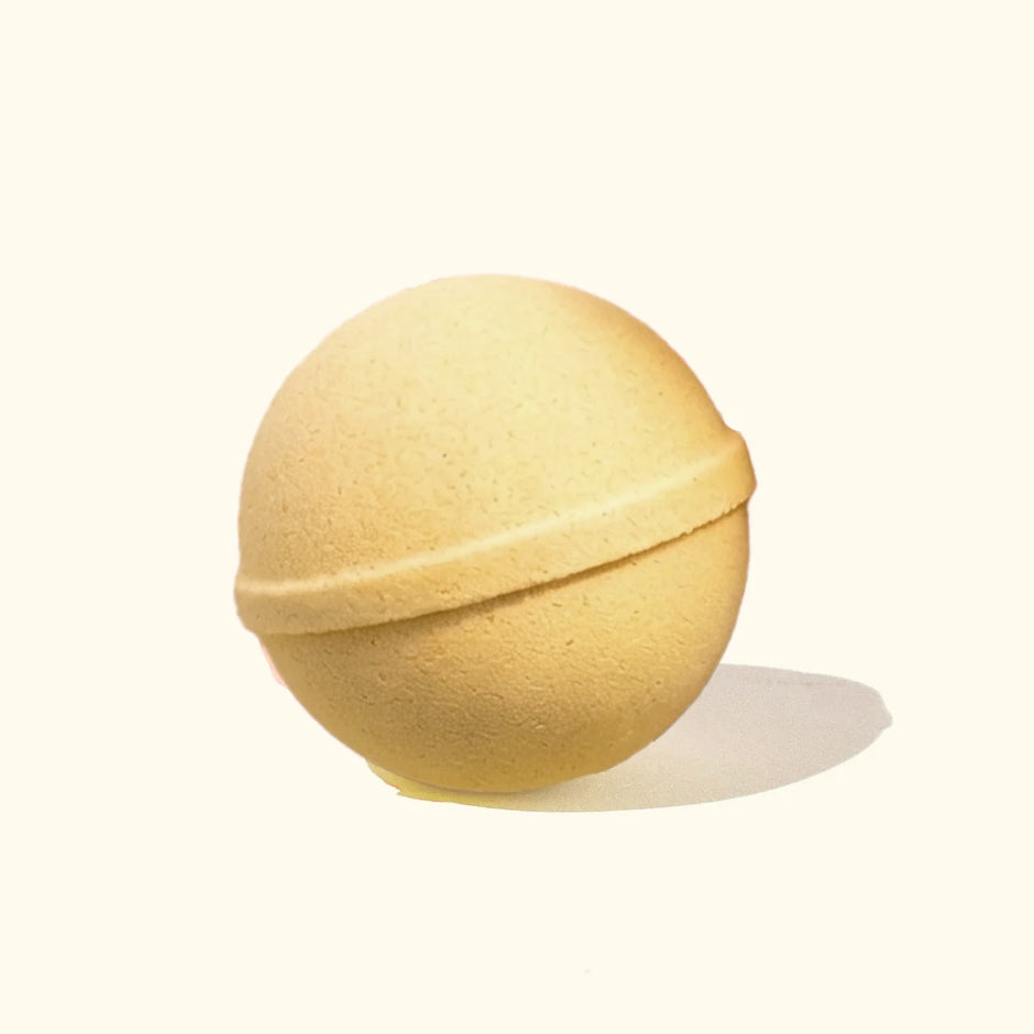 MUSEE American Honey Bath Balm - golden spherical bath bomb with seam detail on neutral background