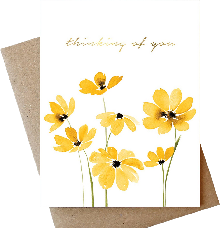 A white greeting card with yellow watercolor flowers and the words 'thinking of you' in gold script, shown with a brown kraft envelope behind it on a white background.
