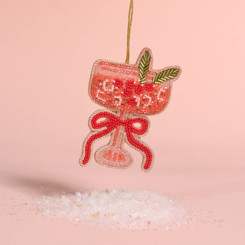 Handcrafted beaded ornament shaped like a cocktail glass with red beads, bow detail, and green leaf accents
