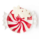 Red and white peppermint striped dessert plate topped with whipped cream, overhead view