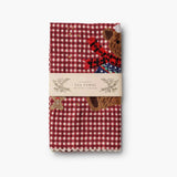 Red and white gingham tea towel with embroidered bear and holiday design, packaged with band