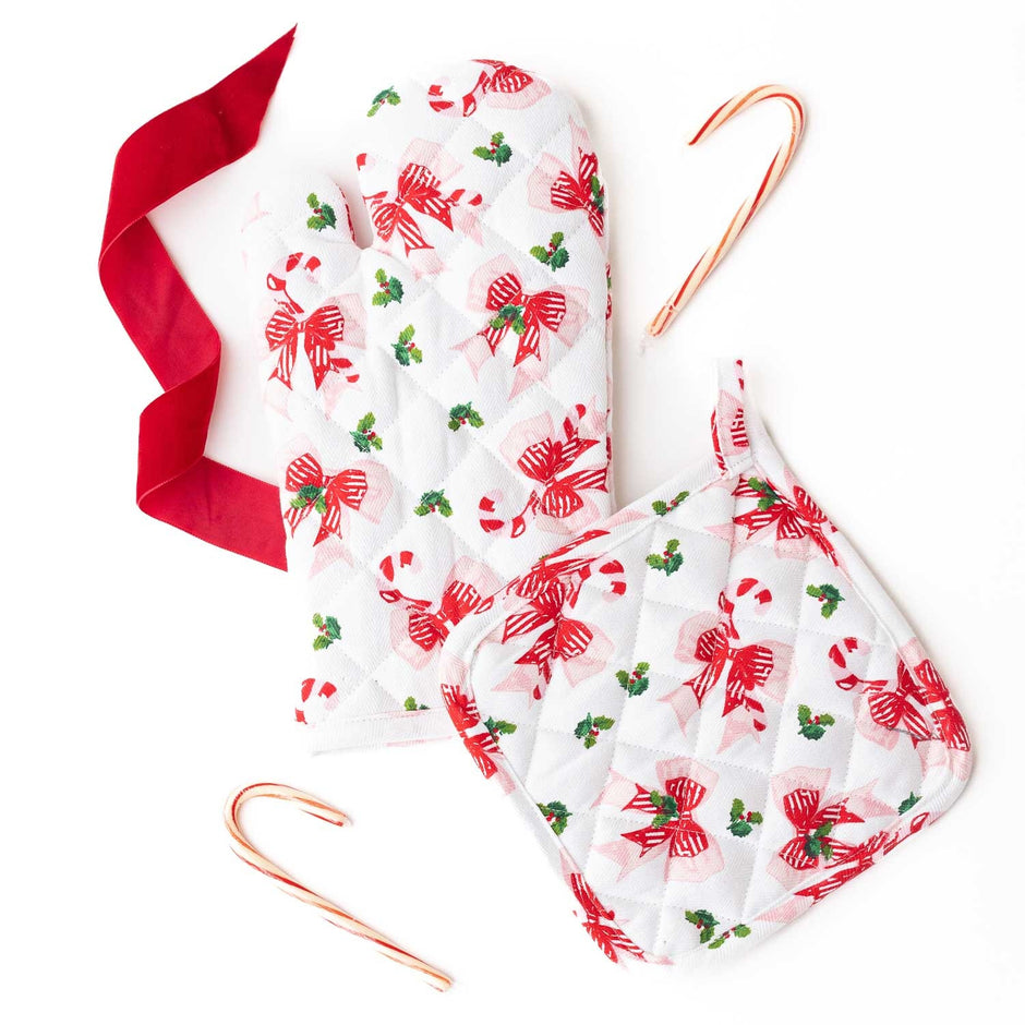 Holly Jolly Bows Oven Mitt Set with red ribbon and candy canes on white background