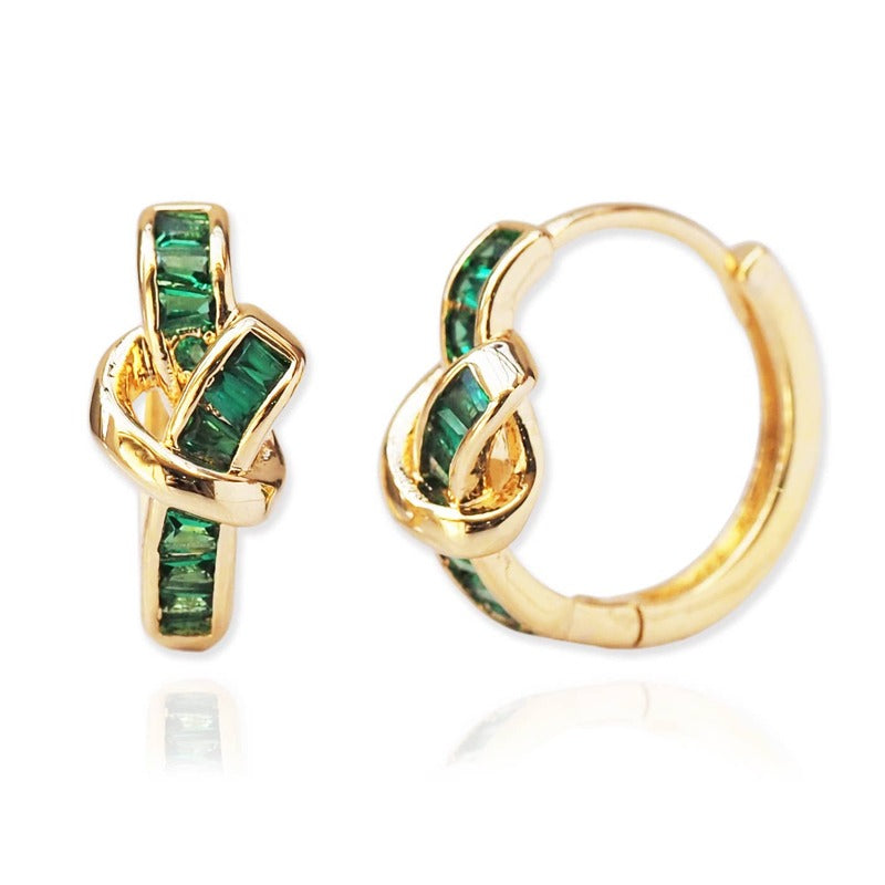Gold huggie earrings with emerald green baguette crystals and love knot design