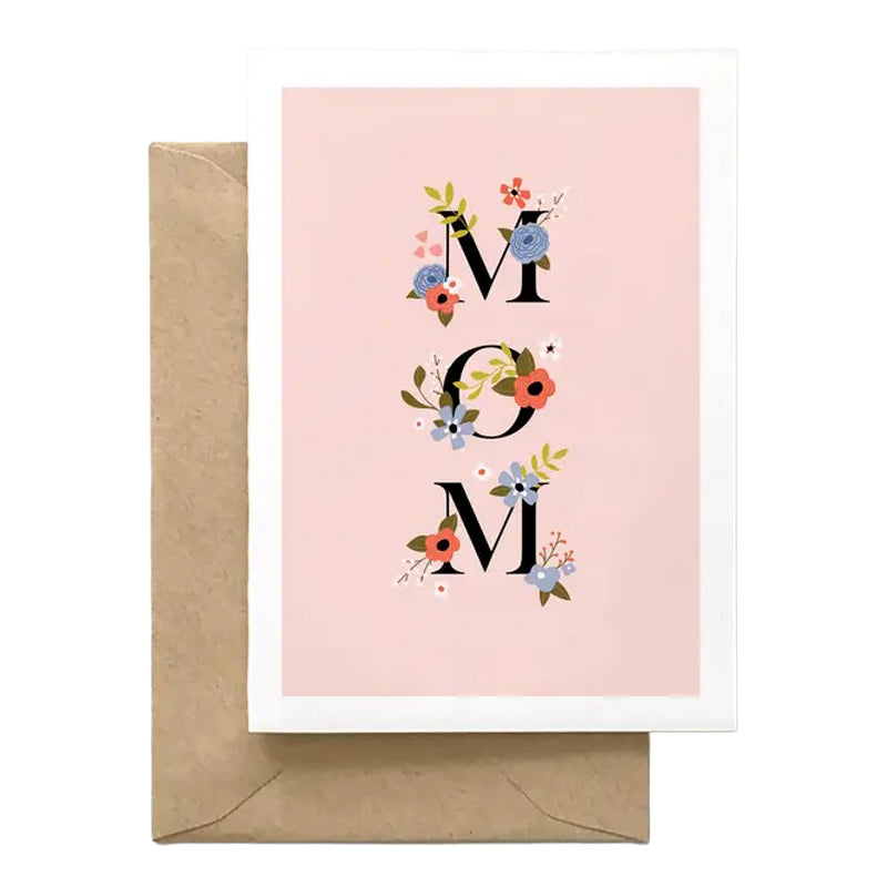 Greeting card with 'MOM' text and floral designs on a pink background, accompanied by a brown envelope.