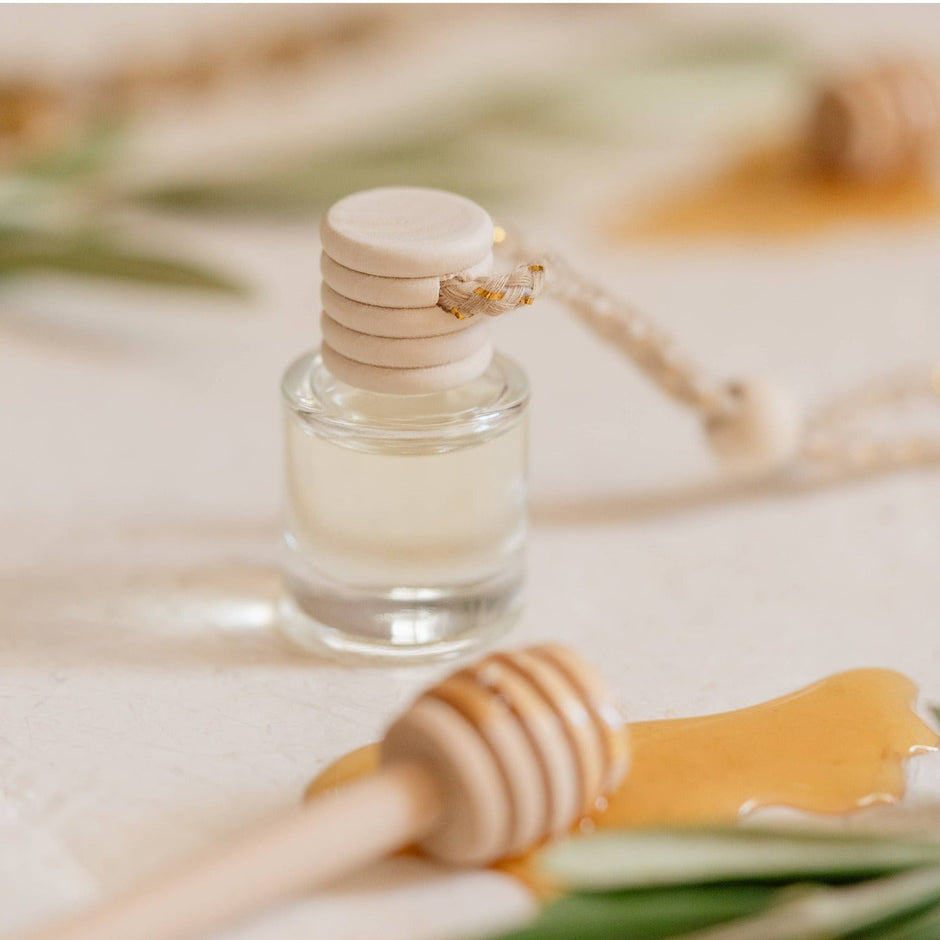 White Tea Car Diffuser with wooden applicator surrounded by fresh botanicals and natural styling elements