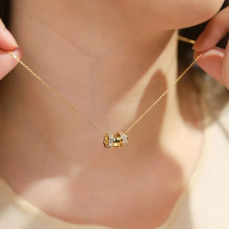 Gold rondelle charm necklace worn by model, delicate chain with textured pendant detail