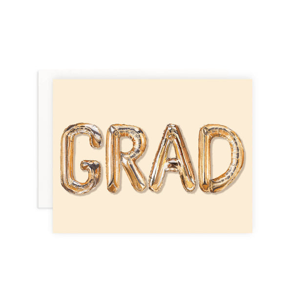 Graduation card with 'GRAD' in metallic letters on a beige background