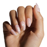 Hand with pink nails featuring floral designs on a white background