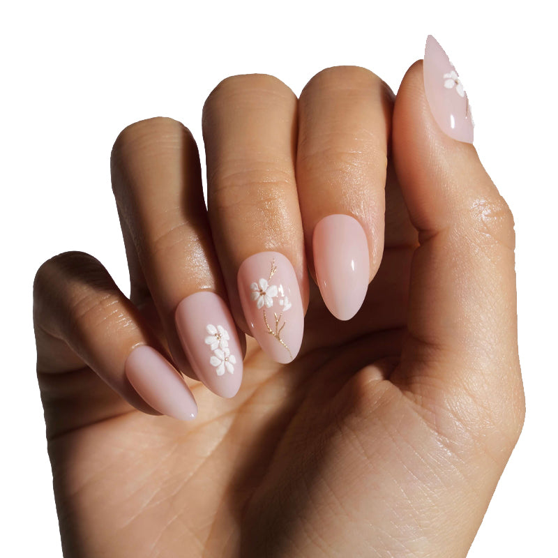 Hand with pink nails featuring floral designs on a white background