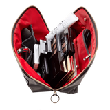 KUSSHI | Vacationer Makeup Bag — Black/Red, An open makeup bag with a red interior and black exterior, shown from above and filled with cosmetics including an eyeshadow palette, compact, and tube on a white background.