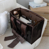 Brown Case-Mate tote organizer filled with accessories and personal items on a white chair