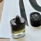 Diptyque 34 Boulevard Saint Germain Eau de Parfum bottle on a painted paper backdrop