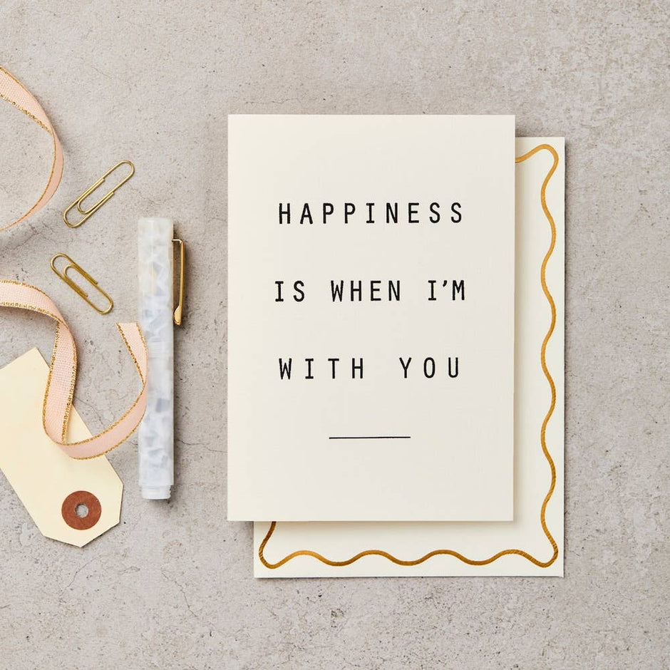 Katie Leamon Happiness greeting card styled with gold accessories on neutral background