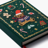 Green embroidered journal featuring a teddy bear in Santa hat surrounded by holiday motifs and gold chain border