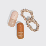 Kitsch hair perfume set with two bottles and champagne silk scrunchie on white background