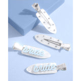 Pearl bride hair clips set with rhinestones and metallic silver hardware on blue background