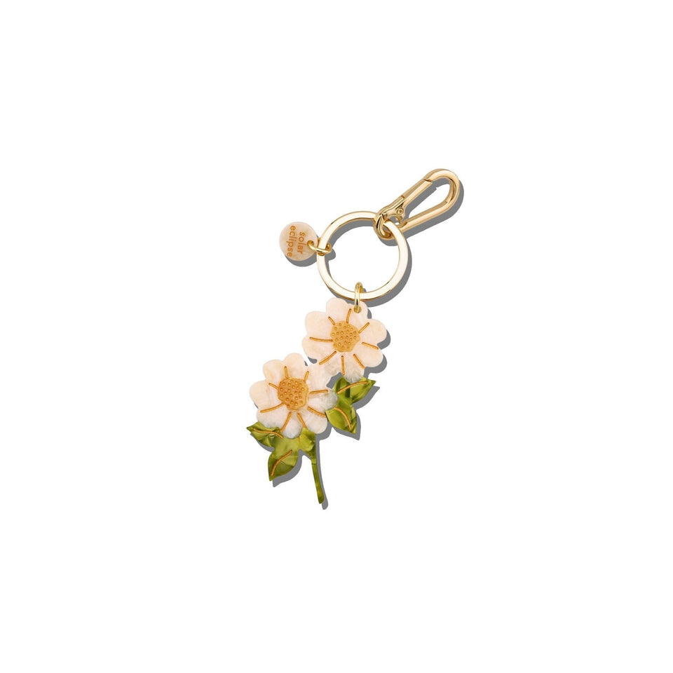 Hand-painted vintage daisy stem bag charm with gold keychain clip on white background