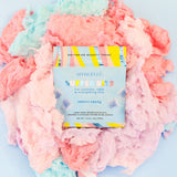 SPONGELLÉ Cotton Candy Buffer Bits displayed on fluffy pink and blue cotton candy background