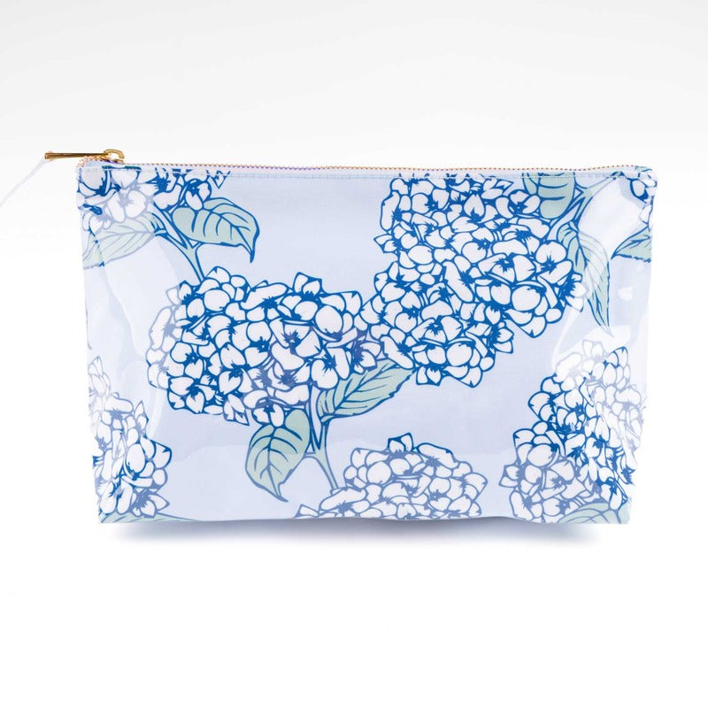 Blue hydrangea floral print clear cosmetic travel case with gold zipper on white background