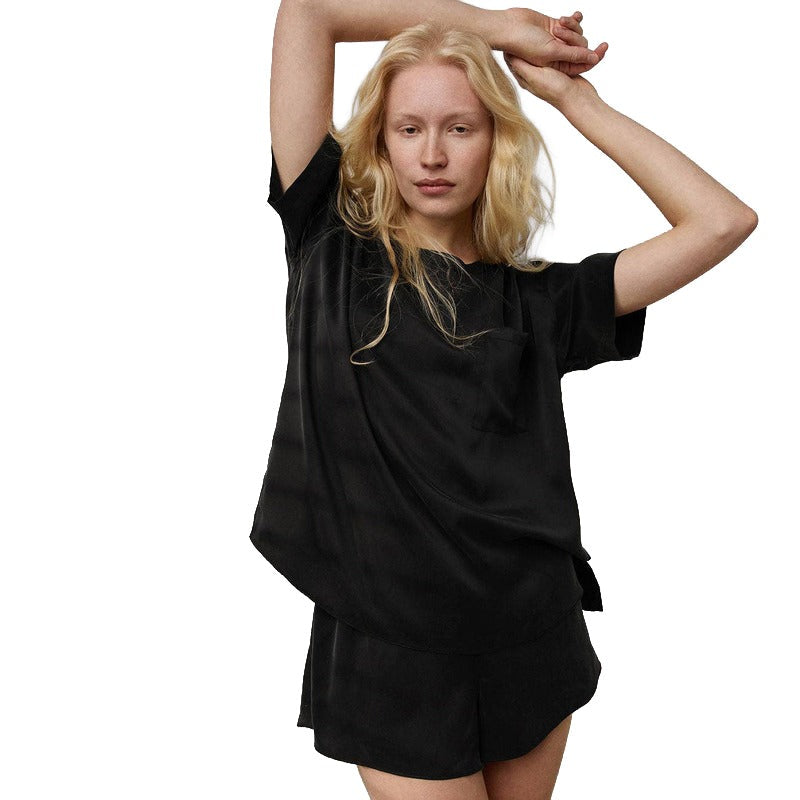 Woman wearing black washable silk tee and shorts set against white background