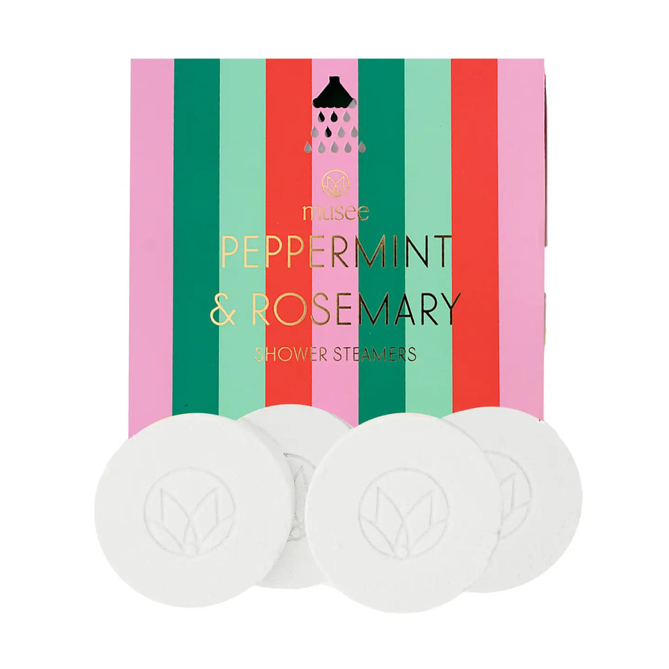 Four round white shower steamers with an embossed leaf logo are arranged in front of their colorful packaging box. The box features vertical stripes of pink, green, red, and mint green with the text 'musee PEPPERMINT & ROSEMARY SHOWER STEAMERS'.