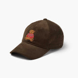 Brown corduroy baseball cap with embroidered teddy bear wearing red sweater