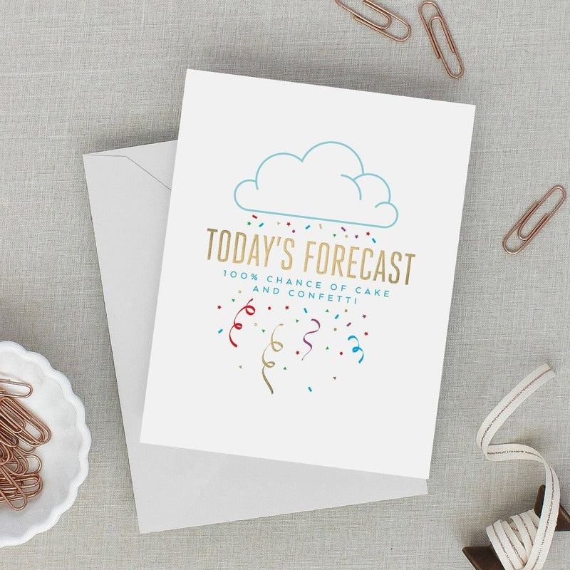 Birthday Forecast greeting card with gold foil text, cloud design, and confetti on neutral background with accessories