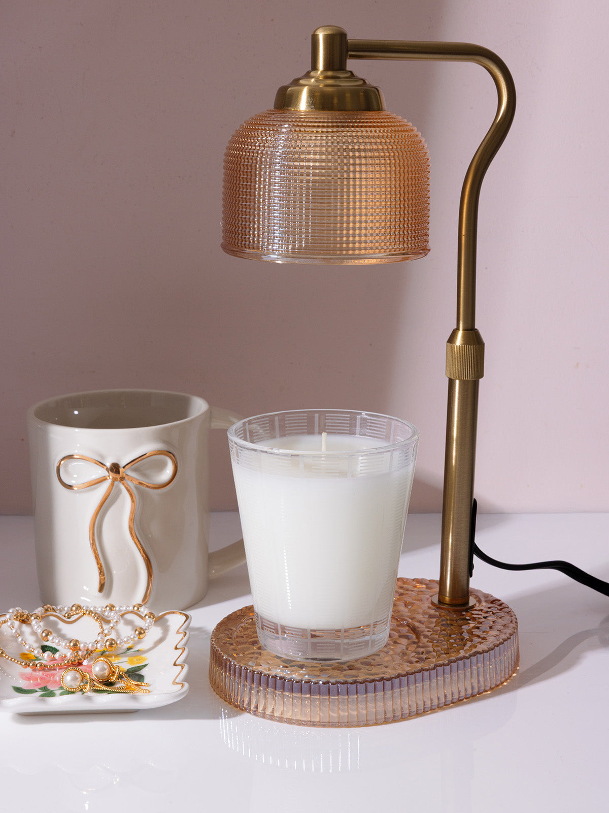 Brass desk candle warmer with Nest candle and bow-accented mug styled for dorm room decor