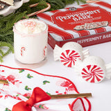 Peppermint bark drink with whipped cream and crushed candy canes, surrounded by festive holiday decorations.