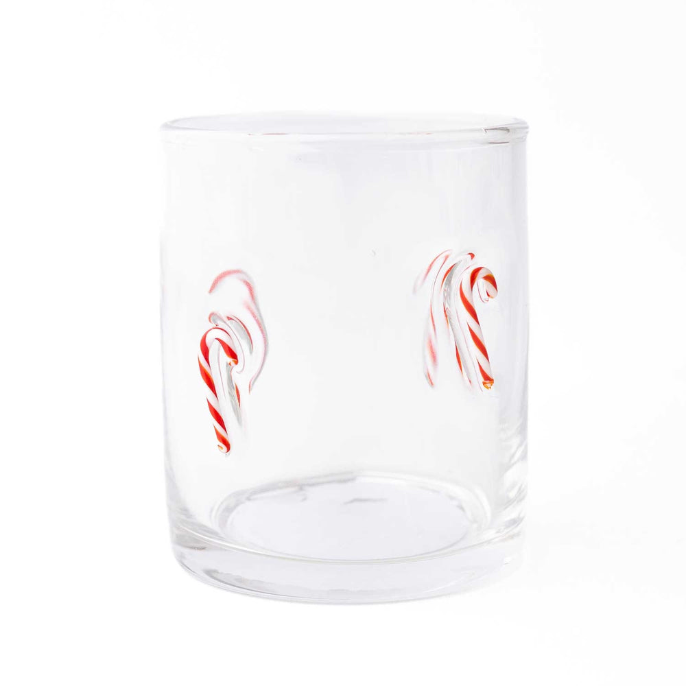 Clear drinking glass with red and white candy cane illustrations on white background