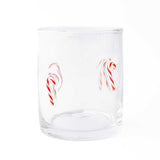 Clear drinking glass with red and white candy cane illustrations on white background