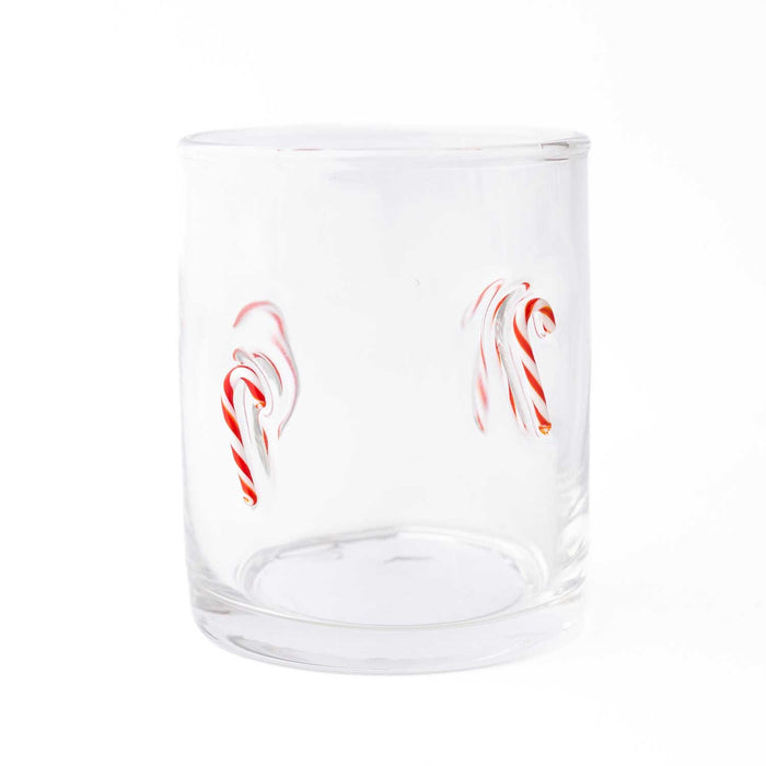 Clear drinking glass with red and white candy cane illustrations on white background