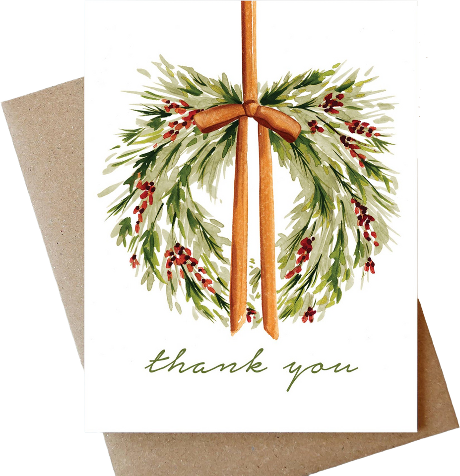 A white greeting card with a watercolor holly wreath design in green, brown, and red, with the words 'thank you' in green script at the bottom. A kraft paper envelope is partially visible behind the card.