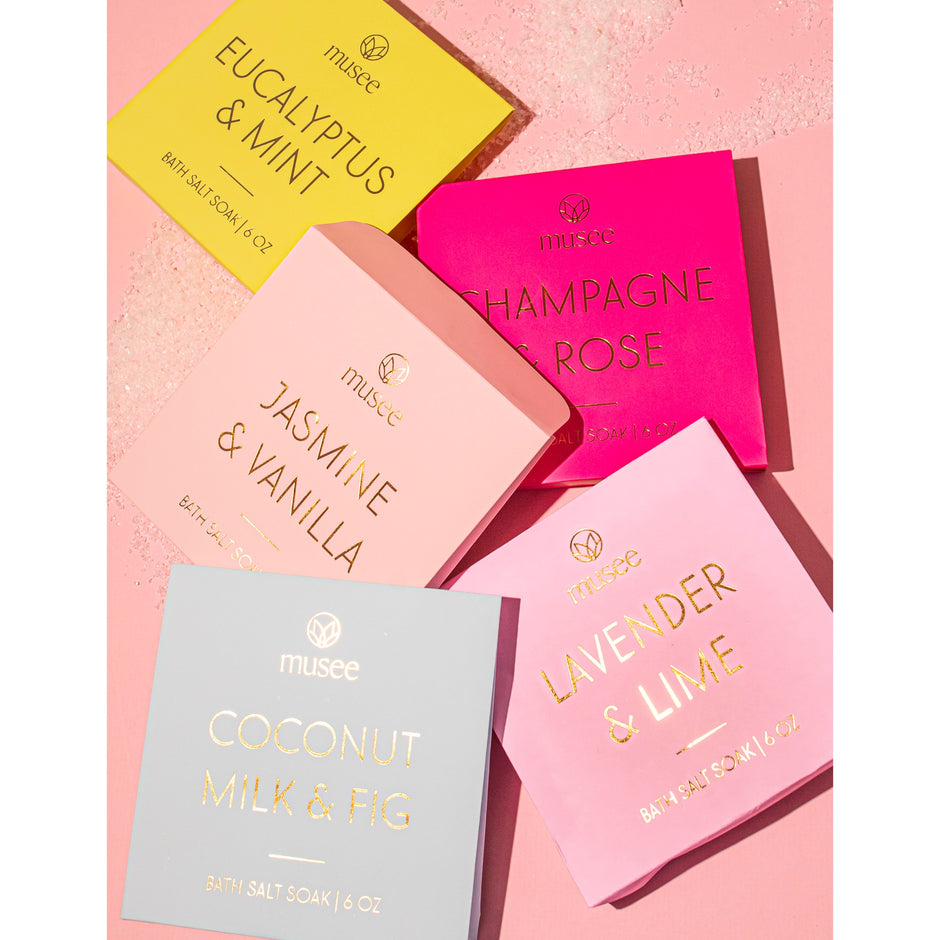 Musee bath salt soak collection displayed on pink background with multiple scented varieties